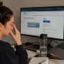 Office worker rubbing tired eyes while researching contact lens options online